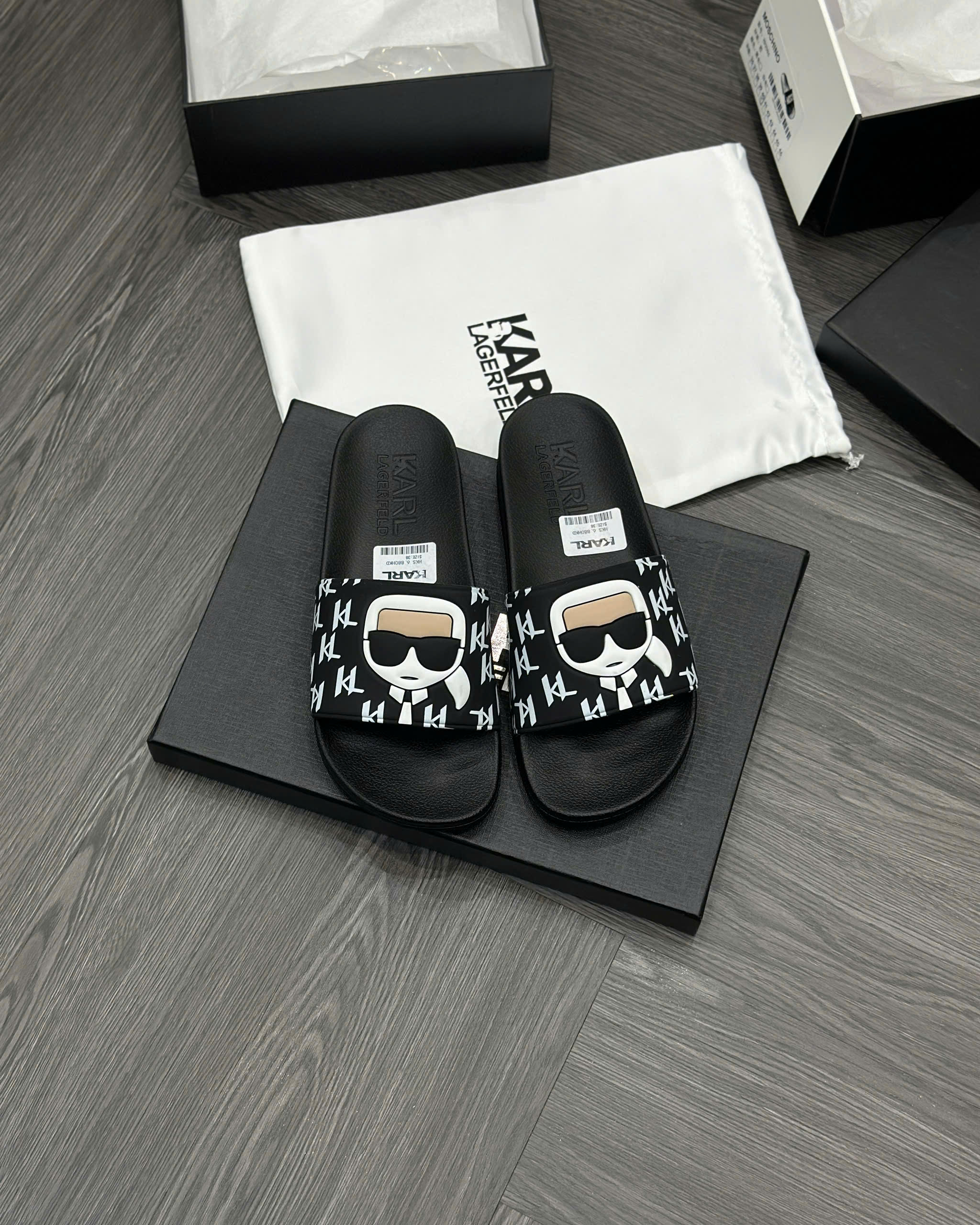 Dép lê quai ngang Karl Đen họa tiết chữ Trắng logo mặt người nổi Like Auth fullbox MVT