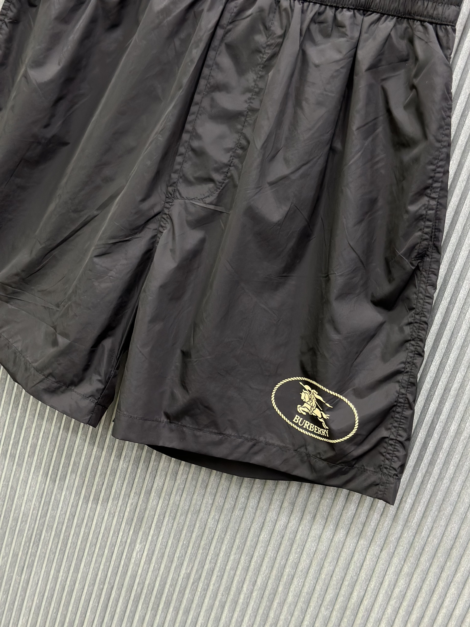 Quần short gió Burberry BBR Đen logo Vàng tròn đùi S-XL VTN